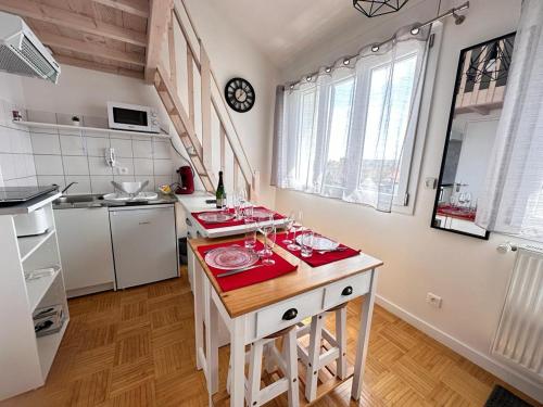 une cuisine avec une table avec de la vaisselle rouge dessus dans l'établissement Le pilier un cocon en duplex proche centre ville, à Reims