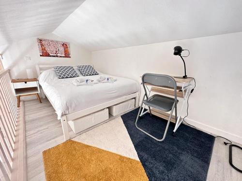 une chambre avec un lit, un bureau et une chaise dans l'établissement Le pilier un cocon en duplex proche centre ville, à Reims