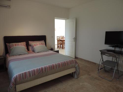 une chambre avec un lit, un bureau et une télévision dans l'établissement Maquis et Mer, à Sollacaro
