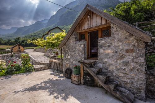 a stone house with a porch and mountains in the background at Zora - moje mjesto in Konjic