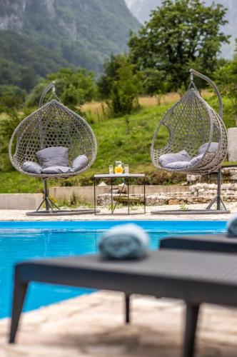 two chairs and a table next to a swimming pool at Zora - moje mjesto in Konjic