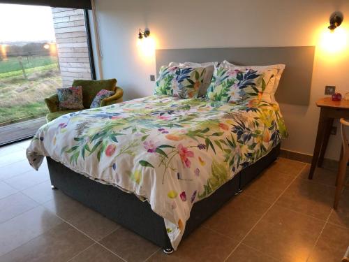 a bedroom with a bed with a floral comforter at Tweed Hideaway in Kelso