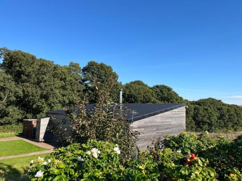 a wooden house in a garden with flowers at Tweed Hideaway in Kelso