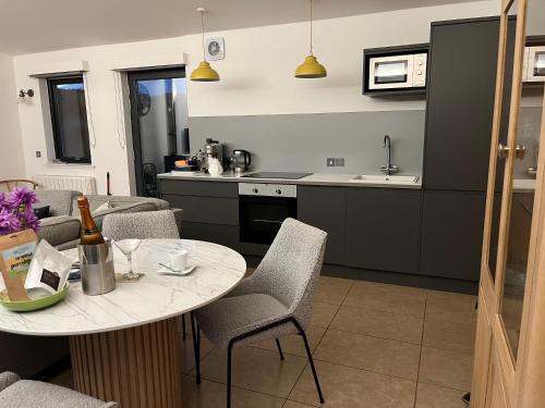 a kitchen and living room with a table and chairs at Tweed Hideaway in Kelso
