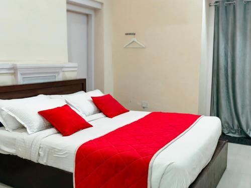 a red and white bed with red pillows on it at Bruton resorts in Kodaikānāl