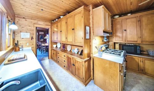 a large kitchen with wooden cabinets and a stove at The Pines of Three Lakes in Eagle River