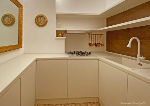 eine Küche mit weißen Schränken und einer Spüle in der Unterkunft Dimora Donizetti 5 in Carovigno