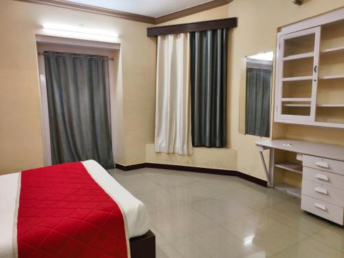 a bedroom with a red bed and a dresser and mirror at Bruton resorts in Kodaikānāl