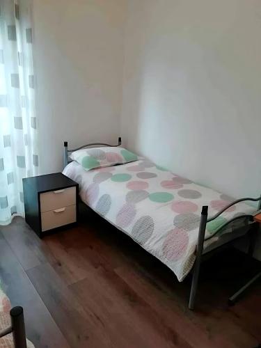 a small bedroom with a bed and a night stand at Gorizia Central Luxe Apartment 6 posti letto in Gorizia