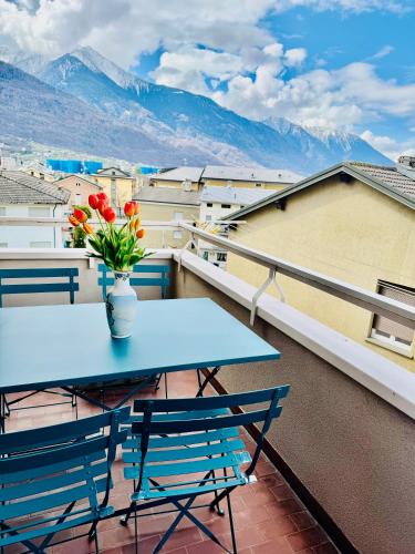 a blue table and chairs on a balcony with mountains at Nido tra monti in Sondrio