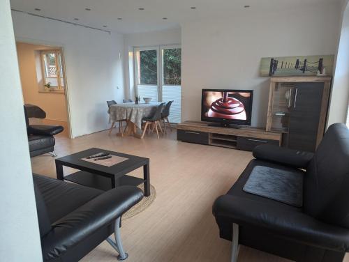 a living room with a couch and a tv at Ferienwohnung Brückenblick 85112 in Ostrhauderfehn
