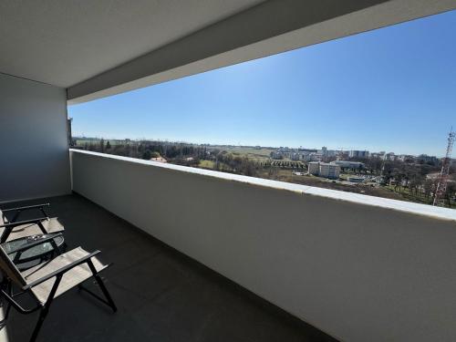 a room with a large window and two chairs on a balcony at Ava Towers Accommodation 1-2 Bdm by GAP with Parking in Suceava
