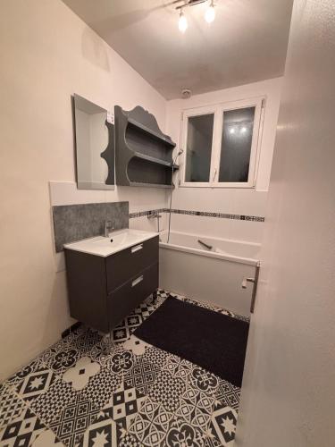 une salle de bain avec un lavabo, une baignoire et un miroir dans l'établissement Maison cosy proche gare SNCF 2 chambres, à Saint-Pierre-des-Corps