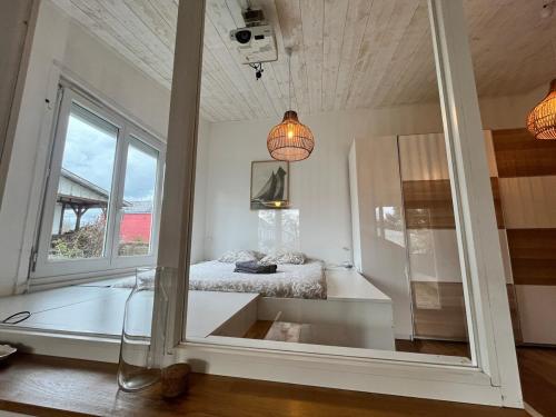 Un dormitorio con una cama y una ventana grande. en Sainte Luce proche de La Loire, en Sainte-Luce-sur-Loire