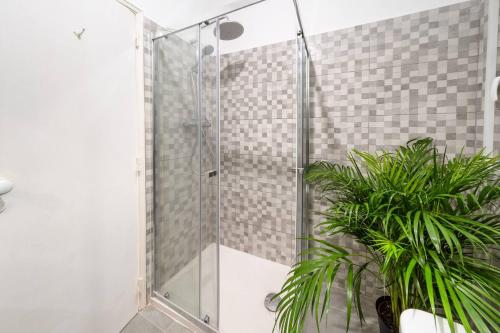 a shower with a glass door next to a plant at Riverfront Elegance 41BR Spacious Retreat in Lisbon