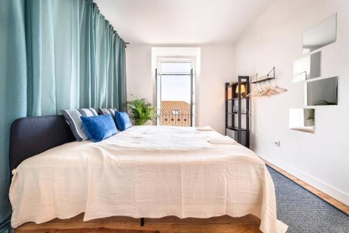 a bedroom with a large white bed with blue pillows at Riverfront Elegance 41BR Spacious Retreat in Lisbon