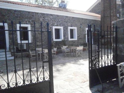 a gate to a brick building with a table and chairs at Olive Press Hotel in Mithymna