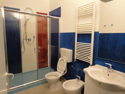 a bathroom with a toilet and a shower and a sink at Pavia Ostello in Pavia