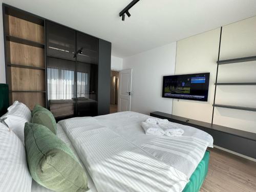 a bedroom with a large bed and a flat screen tv at Ava Towers Accommodation 1-2 Bdm by GAP with Parking in Suceava