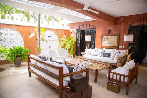a living room with a couch and chairs and a table at The House on The Sand - Malindi in Malindi