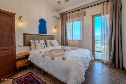 a bedroom with a large bed and a large window at Casa maravillosa in Chefchaouene