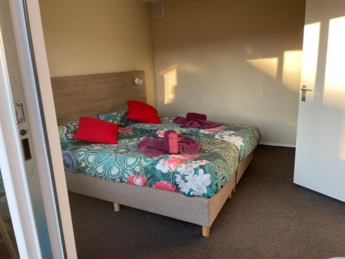 a bedroom with a bed with red pillows at Fisherman's House by Hofstad Hotels in Scheveningen
