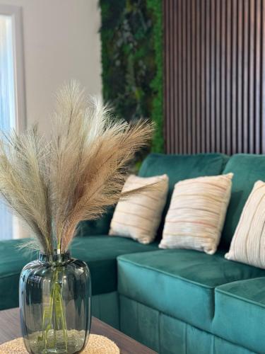 a vase with feathers in it sitting on a table with a couch at Ava Towers Accommodation 1-2 Bdm by GAP with Parking in Suceava