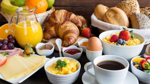 a breakfast table with breakfast foods and drinks at HOME Hostel im Schönhof-Viertel in Frankfurt/Main
