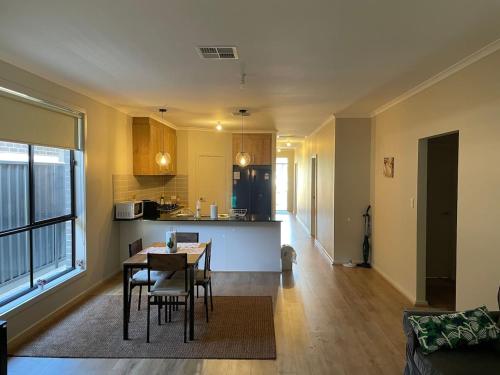 a living room and kitchen with a table and chairs at Modern Brand New 4BR Family Home Walkable to Shops in Smithfield