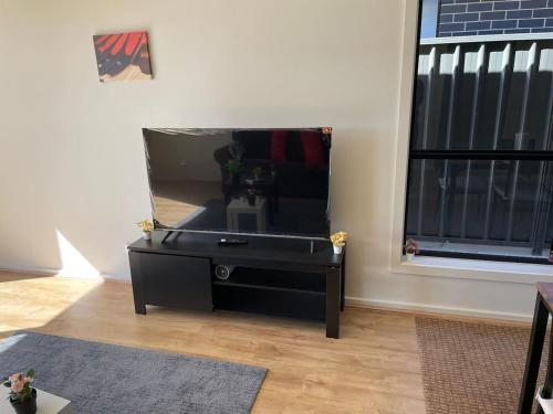 a black dresser with a mirror in a room at Modern Brand New 4BR Family Home Walkable to Shops in Smithfield