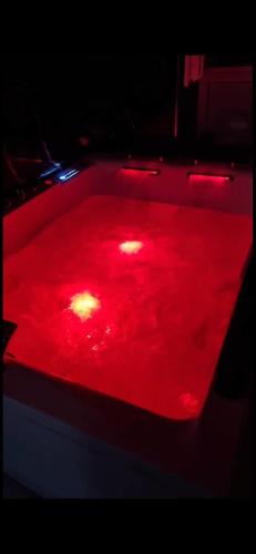 une lumière rouge au-dessus d'un billard dans l'établissement Suite Neptune Jaccuzi, à Pont-Saint-Esprit