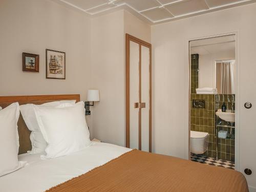 a bedroom with a bed and a bathroom with a shower at Hôtel du Savoir in Paris