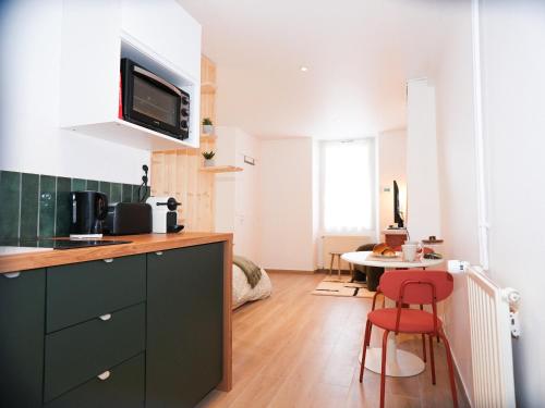 - une cuisine avec un comptoir et une table dans une pièce dans l'établissement Logement rénové proche de la gare RER TGV, à Massy