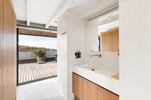 a bathroom with a sink and a view of a patio at Duinhotel Tien Torens in Zoutelande