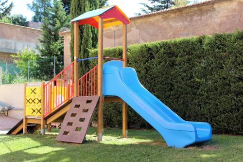 a playground with a slide in the grass at Le Corti Del Sole Residence in Venturina Terme