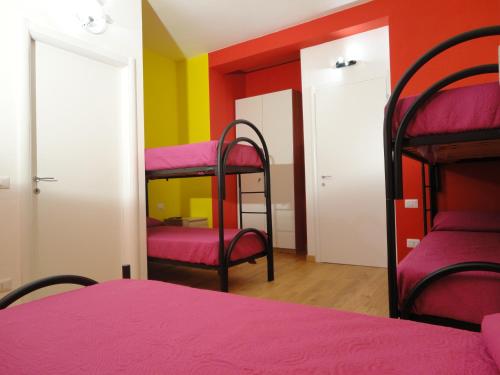 a bedroom with two bunk beds and a red wall at Pavia Ostello in Pavia
