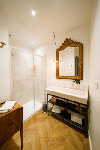 une salle de bain avec un lavabo, une douche et un miroir dans l'établissement Maison Gaspard - Suites et appartements de charme à Saumur, à Saumur