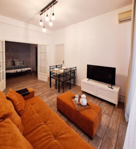 un salon avec un canapé et une télévision dans l'établissement Two bedrooms apartment near beach, à Cannes