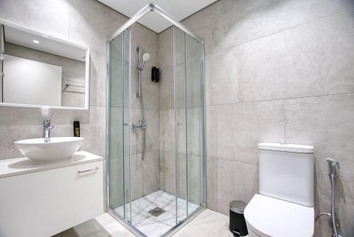 a bathroom with a shower and a toilet and a sink at Avenue 101 2 BED in Paphos