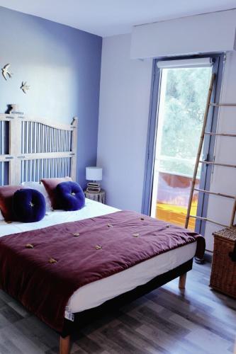 - une chambre avec un lit doté d'oreillers violets et d'une fenêtre dans l'établissement Fréjus plage: appartement cosy à 300m de la mer, à Fréjus