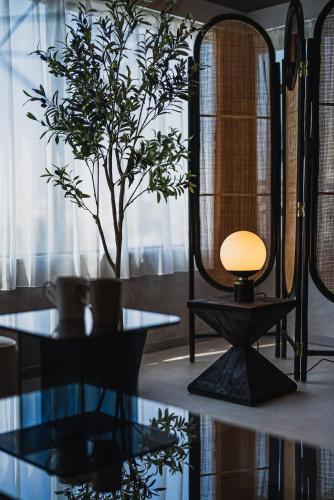 a table with a lamp and a plant in a room at Luxury Stay near Azabudai Hills and Tokyo Tower, 2-Bedroom Apartment in Tokyo