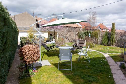 a table and chairs in a yard with an umbrella at Studio Rouffach in Rouffach