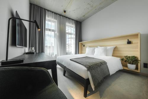 a hotel room with a bed and a desk at OTTO Hotel & Sun in Pāvilosta