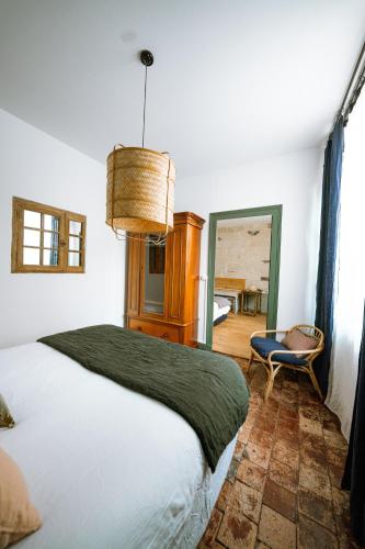 une chambre avec un lit, une chaise et un miroir dans l'établissement Maison Gaspard - Suites et appartements de charme à Saumur, à Saumur