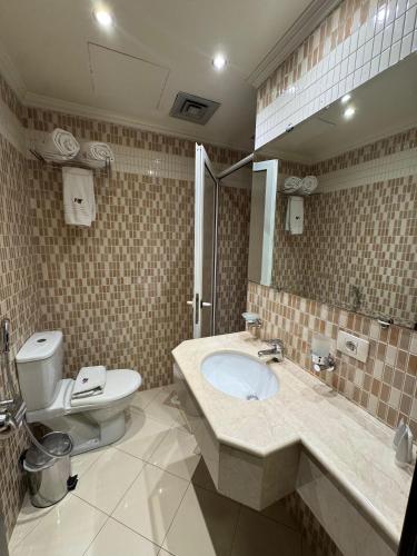 a bathroom with a sink and a toilet and a mirror at Ny Suites in Beirut