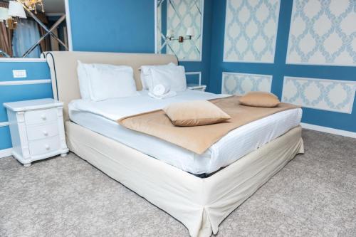 a large bed in a room with blue walls at Villa Boutique Lafayette in Bucharest