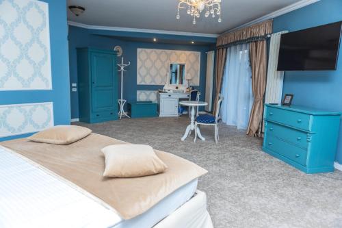 a bedroom with blue walls and a bed and a desk at Villa Boutique Lafayette in Bucharest