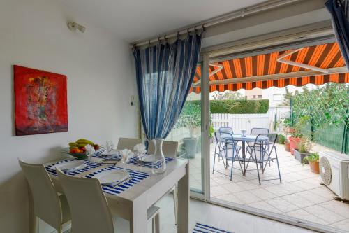 une salle à manger avec une table et des chaises ainsi qu'une terrasse dans l'établissement Le Pagnol - Studio proche plage, au Grau-du-Roi