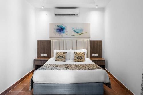 a bedroom with a bed with white sheets and pillows at Pickalbatros Palace - Aqua Park Hurghada in Hurghada