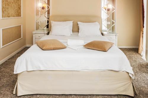 two beds in a bedroom with white sheets and pillows at Villa Boutique Lafayette in Bucharest